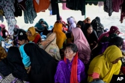 Perempuan etnis Rohingya berlindung di bawah tenda dekat pantai tempat mereka mendarat pada 10 Desember di Pidie, Aceh, 16 Desember 2023. (Foto: AP)
