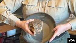 Lori Šular pokazuje kamen sa zlatom i posudu za ispiranje zlata.