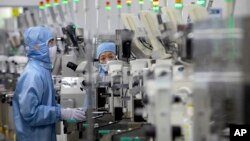 Zaposleni koji nose zaštitnu opremu rade u pogonu za proizvodnju poluprovodnika za Renesas Electronics u Pekingu, Kina, 14. maja 2020.