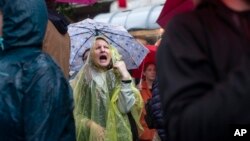 A woman shouts as she attends a protest in front of the state-run TV headquarters in Belgrade, Serbia, May 27, 2023.