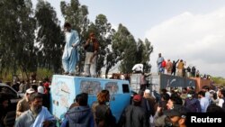 Supporters of former Pakistani Prime Minister Imran Khan climb on shipping containers, placed to block the road, during a clash outside the federal judicial complex in Islamabad, March 18, 2023.