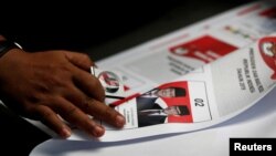 Seorang pekerja menggunakan kaca pembesar saat memeriksa surat suara yang dicetak untuk pemilihan presiden di sebuah pabrik di Jakarta, 20 Januari 2019. (Foto: REUTERS/Willy Kurniawan)