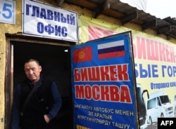 FILE - Kyrgyz male labor migrants wait to leave to work in Russia at the office of a company organizing passenger transportation to Russia in Bishkek, Oct. 17, 2023.