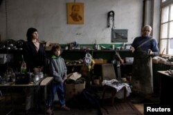 Dmytro Mamonov, his wife Oksana and daughter Yesenia stand in their workshop, May 31, 2024. (REUTERS/Thomas Peter)