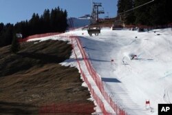 FILE - An athlete speeds down the course during an alpine ski, men's World Cup giant slalom race, in Adelboden, Switzerland, Jan. 7, 2023. Mother Nature and global warming are having just as much say about when and where to hold ski races these days as the International Ski Federation.