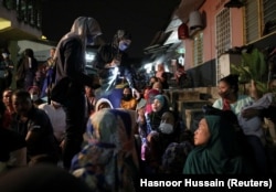 Seorang petugas imigrasi memeriksa dokumen para imigran saat razia imigrasi, sesaat setelah program rekalibrasi untuk pemulangan imigran gelap berakhir, di Segambut, Kuala Lumpur, Malaysia 1 Juli 2022. (Foto: REUTERS/Hasnoor Hussain)