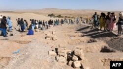 Afghans dig graves to bury earthquake victims in Sarbuland village, Zinda Jan district of Herat province, Oct. 8, 2023.
