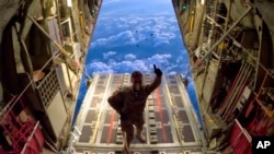 FILE - In this photo provided by the French army, a soldier gestures before air-dropping some material over the Gaza Strip, on Jan. 4, 2024.