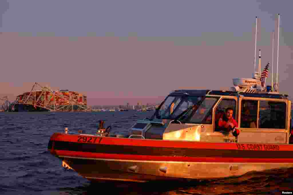A U.S. Coast Guard vessel secures the perimeter after the Dali cargo vessel crashed into the Francis Scott Key Bridge, causing it to collapse in Baltimore, March 26, 2024.