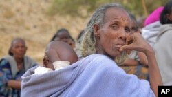 አንዲት አረጋዊ እናት፣ በትግራይ ክልል፣ ማይ መቅደን ከተማ፣ ማክሰኞ፣ የካቲት 19 ቀን የተካሄደውን ስብሰባ ህፃን በጀርባቸው አዝለው ሲካፈሉ ይታያሉ። ፊታቸው በጭንቀት የተሞላ እናቶች ልጆቻቸው በምግብ እጦት ሲዳከሙ እርዳታ በማጣት ይመለከታሉ። የኢትዮጵያ፣ ትግራይ ክልል አሁን ሰላማዊ ቢሆንም፣ ጦርነቱ ትቶት የሄደው ጠባሳ ከድርቅ እና የእርዳታ አያያዝ ጉድለት ጋር ተደማምሮ፣ ከፍተኛ ተፅእኖ እያደረሱ ነው። (ፎቶ፡ ተስፋለም ግርማይ አሰፋ)