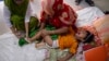 FILE - A paramedic gives an injection to a child suffering from dengue at Mugda Medical College and Hospital in Dhaka, Bangladesh, Aug. 10, 2023. 