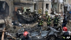 Vatrogasci rade na gašenju požara u uništenoj stambenoj zgradi nakon ruskog napada u Kijevu, Ukrajina, 2. januara 2024.