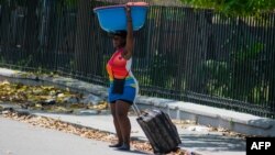 A woman leavevs an area that was set fire to by armed gangs in Port-au-Prince, Haiti, on March 25, 2024.