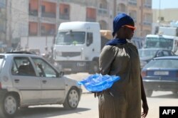 FILE - A vendor sells plastic sachets filled with drinkable water in Dakar, on Aug. 23, 2023.