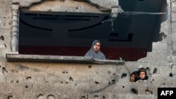 Seorang perempuan dan anak-anak Palestina menyaksikan pengeboman Israel di Rafah, di Jalur Gaza selatan, di tengah berlanjutnya pertempuran antara Israel dan Hamas. (Foto: AFP)