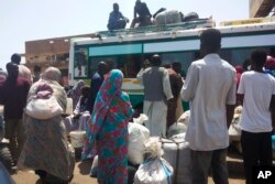 FILE - People board a bus to leave Khartoum, Sudan, on June 3, 2023, as fighting between the Sudanese Army and paramilitary Rapid Support Forces intensified.