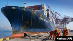 2024년 2월 11일 중국 동부 산둥성 청도항에서 노동자들이 컨테이너 선박을 정박시키고 있다. (자료사진)