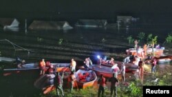 Rescue workers search for stranded residents with boats after waters breached a dike at Dongting Lake and led to flooding in Huarong County of Yueyang, Hunan Province, China, July 6, 2024.