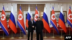 In this pool photograph distributed by the Russian state agency Sputnik, Russia's President Vladimir Putin shakes hands with North Korea's leader Kim Jong Un during a meeting in Pyongyang on June 19, 2024. (Gavriil Grigorov/ Pool / AFP) 