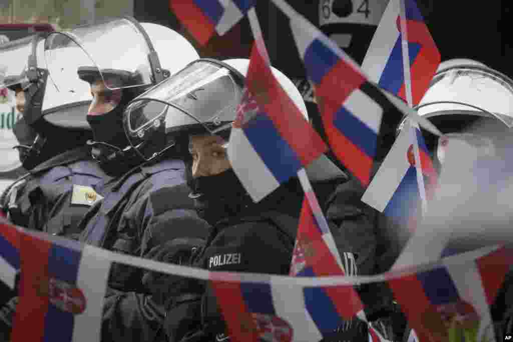 Police stand next to a restaurant decorated with Serbian flags ahead the Group C match between Serbia and England at the Euro 2024 soccer tournament in Gelsenkirchen, Germany.
