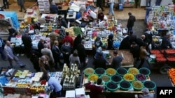 FILE - Iraqi Kurdish people walk in a street market in Erbil, in the Kurdish Region of northern Iraq, Feb. 16, 2016.