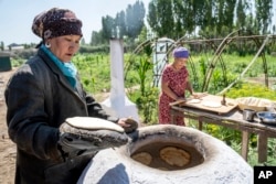 Women bake bread during a party in their house in the village of Shege, next to the disappearing Aral Sea, near Muynak, Uzbekistan, July 12, 2023.