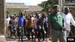 Zimbabwe Prisons and Correctional Services officials open gates to allow pardoned prisoners to leave, at Chikurubi Maximum Prison in Harare, on April 19, 2024. (Columbus Mavhunga/VOA)