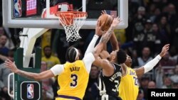Giannis Antetokounmpo (34) de Milwaukee tente un tir contre devant Anthony Davis (3) des Los Angeles Lakeres, USA, le 26 mars 2024.
