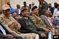 FILE - In this file photo taken on December 05, 2022 Sudan's Army chief Abdel Fattah al-Burhan (2nd-L) and paramilitary commander Mohamed Hamdan Daglo (L) attend the signing ceremony of an initial deal with civilian leaders aimed at ending a deep crisis caused by last year's military coup, in Khartoum. (Photo by ASHRAF SHAZLY / AFP)