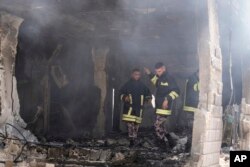 Palestinian firefighters work in the rubble of a home destroyed in an Israeli military operation in the West Bank city of Jenin, July 5, 2024.