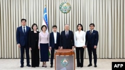 A handout photograph released by the Press Service of the President of Uzbekistan on April 30, 2023, shows Uzbek President Shavkat Mirziyoyev (3R) with his family during a visit to a polling station in Tashkent with his family. 