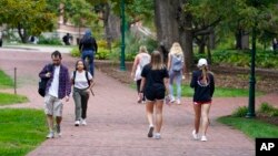 Students walk to and from classes on the Indiana University campus, Oct. 14, 2021, in Bloomington, Ind. 