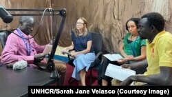 In this undated photo provided by UNHCR, radio journalist Jabrallah Tia interviews members of the UNHCR Forced Displacement survey specialists.