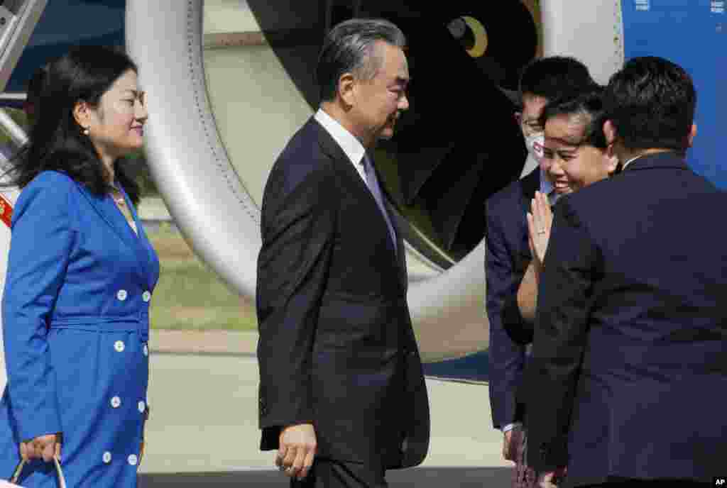 រដ្ឋមន្ត្រី​ការបរទេស​ចិន​លោក Wang Yi (កណ្ដាល) បាន​អញ្ជើញ​មក​ដល់​អាកាសយានដ្ឋាន​អន្តរជាតិ​ភ្នំពេញ នៅ​ថ្ងៃសៅរ៍ ទី ១២ ខែសីហា ឆ្នាំ ២០២៣ ដើម្បី​បំពេញ​ទស្សនកិច្ច​រយៈពេល ២ ថ្ងៃ​នៅ​ទីនោះ។ (AP Photo/Heng Sinith)