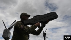 FILE - A Ukrainian serviceman tests an anti-drone gun during a presentation of radio-electronic warfare (WB) and radio-electronic intelligence (PER) systems of the Ukrainian company Kvertus in Lviv region on May 28, 2024.