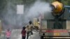 Anak-anak tampak berlari di belakang truk yang menyemprotkan air di sepanjang jalanan New Delhi, India, pada 28 Mei 2024. (Foto: AFP/Arun Sankar)