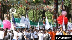 រូបឯកសារ៖ កម្មករកម្មាការិនី កំពុងដើរដង្ហែនិងលើកបដាស្រែកទាមទារសិទ្ធិការងារនិងសិទ្ធិសហជីព ក្នុងកម្មវិធីទិវាអបអរពលកម្មអន្តរជាតិលើកទី១៣៨ នៅសួនច្បារក្រុមប្រឹក្សាអភិវឌ្ឍកម្ពុជា (CDC) នៅរាជធានីភ្នំពេញ នាថ្ងៃទី១ ខែឧសភា ឆ្នាំ២០២៤។ (លាស់ លីបលីប/វីអូអេ)
