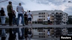 People stand near the site of a Russian missile strike, amid Russia's attack on Ukraine, in Zaporizhzhia, Aug. 10, 2023.
