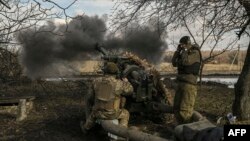 Ukrainian servicemen fire a 105mm Howitzer towards Russian positions, near the city of Bakhmut, March 4, 2023. 