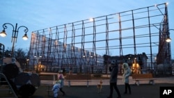 People walk past the destroyed Mariupol's theater, after the first anniversary of Russia's invasion of Ukraine in Mariupol in Russian-controlled Donetsk region, eastern Ukraine, Feb. 25, 2023.