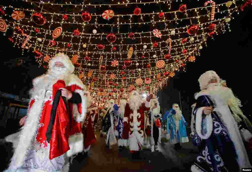 Para peserta berpakaian seperti Ayaz Ata (Bapa Frost) - setara dengan Sinterklas dalam bahasa Kazakh, mengikuti prosesi melalui jalan-jalan kota, menandai musim Tahun Baru dan Natal di Almaty, Kazakhstan.