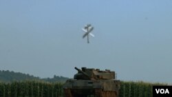 24일 북한 평양 국방과학원 무인기연구소에서 공개된 무인공격기가 목표물로 보이는 장갑차 위에서 수직낙하하는 모습. (사진출처: 조선중앙통신)