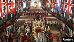 The Gold State Coach is ridden alongside members of the military during a full overnight dress rehearsal of the Coronation Ceremony of Britain’s King Charles and Camilla, Queen Consort in London, Britain.