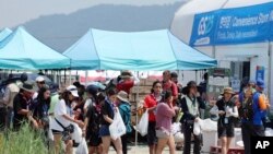 ผู้เข้าร่วมงานชุมนุมลูกเสือโลกพากันเดินออกมาจากร้านสะดวกซื้อที่บริเวณค่ายในเมืองพวน เกาหลีใต้ เมื่อวันที่ 2 ส.ค. 2023