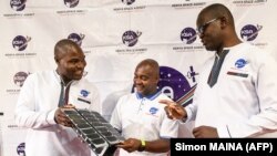 Les ingénieurs de l'Agence spatiale kényane (KSA) Aloyce Were (à gauche), Deche Bungule (au centre) et Andrew Nyawade qui ont conçu et développé le premier satellite opérationnel kényan d'observation de la terre Taifa-1, à l'Université de Nairobi au Kenya, le 14 avril 2023.