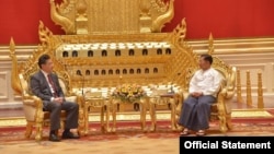In this photo provided by the Myanmar Military True News Information Team, Senior Gen. Min Aung Hlaing, right, head of the military council, shakes hands with Chinese Foreign Minister Qin Gang, left, during their meeting Tuesday, May 2, 2023, in Naypyitaw, Myanmar.