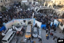 Palestinians inspect debris after an Israeli strike near a United Nations Relief and Works Agency for Palestine Refugees (UNRWA) school in Khan Yunis, in the southern Gaza Strip, Oct. 21, 2023.
