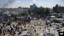 Palestinians inspect the damage at a site hit by an Israeli bombardment on Khan Younis, southern Gaza Strip, July 13, 2024.