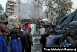 Orang-orang berkumpul di dekat konsulat Iran di ibu kota Suriah, Damaskus, 1 April 2024. (Foto: REUTERS/Firas Makdesi)