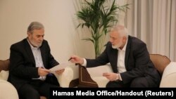 하마스 지도자 이스마일 하니예(오른쪽)과 이슬라믹 지하드 지도자 지야드 알나할라즈가 11일 카타르 도하에서 이집트, 카타르 중재자들과 만나기 앞서 방안을 논의하고 있다. (자료 사진)